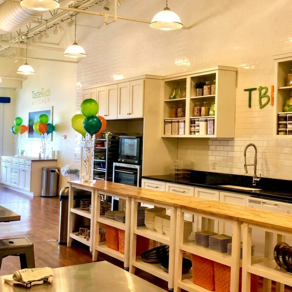 Bright, modern kitchen with white subway tile, wooden tables, and colorful balloons for a celebration.
